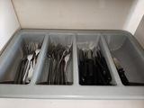 a lot of forks and spoons in a container