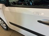 a small white car with a broken window in a garage