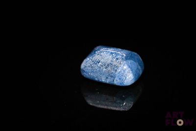 un gros plan d'une pierre bleue posée sur une surface noire