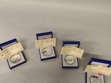 a group of five silver coins sitting on top of a table
