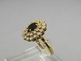a gold ring with a black stone surrounded by white diamonds