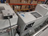 a laptop computer sitting on top of a machine in a warehouse