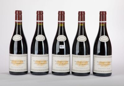 six bottles of wine are lined up on a white surface