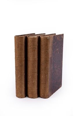 several old books stacked on top of each other on a white surface