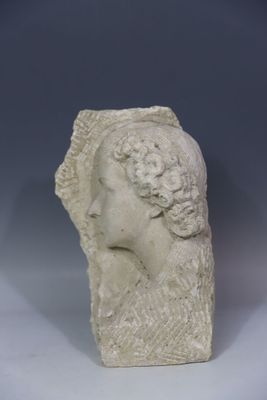 un gros plan sur la tête d'une femme sculptée, posée sur une surface blanche