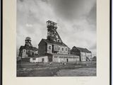 photographie en noir et blanc d'une ancienne usine avec une tour horloge en arrière-plan
