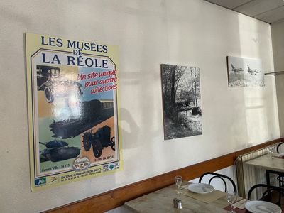 des tables et des chaises dans un restaurant avec des affiches accrochées au mur
