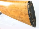 an old wooden rifle with a wooden barrel on a white surface