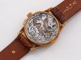 a close up of a watch on a white surface
