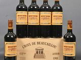 six bottles of red wine in a wooden crate on a table