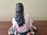 a figurine of a woman sitting on a table