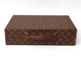 a brown and tan louis vuitton suitcase on a white surface