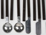 a lot of spoons and spoon knives on the table