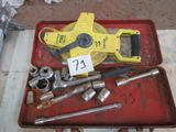 un plateau rouge posé sur une table, sur lequel se trouvent des outils