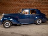 a blue car that is parked in front of a brick wall