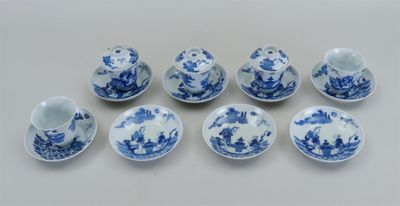 six tasses et soucoupes bleues et blanches posées sur une surface blanche