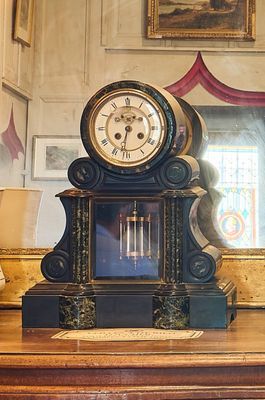 une horloge posée sur une table devant un miroir