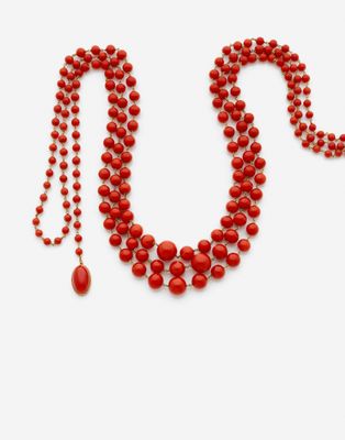 gros plan d'un collier de perles rouges sur fond blanc