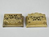 two antique brass bookends with flowers and leaves on them