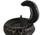 a black snake that is sitting on top of a bowl
