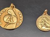 un gros plan sur deux pendentifs en forme de pièces d'or posés sur une table