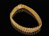 a gold bracelet on a black background