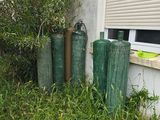 trois cylindres verts devant un bâtiment doté d'une fenêtre