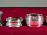 three silver vases sitting on a red cloth on a table