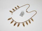 une image représentant un collier en or orné de fleurs et de feuilles