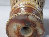 a brown vase that is sitting on a white surface