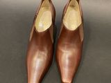 a pair of brown shoes sitting on top of a black surface