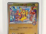 La carte Pokémon se trouve dans un étui en plastique transparent posé sur une surface blanche.