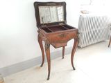 a small wooden table with a mirror on top of it