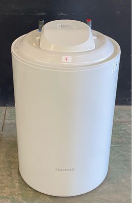 a white trash can sitting on the floor next to a black wall