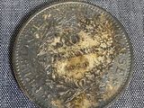 two coins that are on a table next to each other