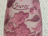a pink vase with flowers on it sitting on a table