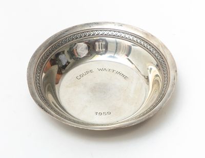 a silver plate with a picture on it on a white surface