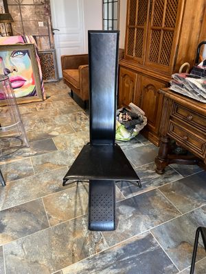 une chaise noire posée sur un sol carrelé