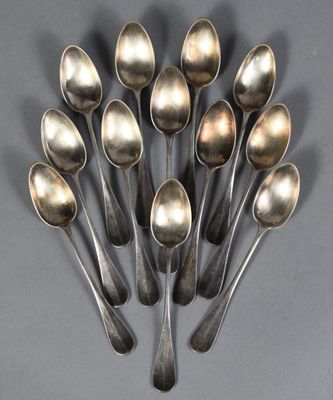 six silver spoons are arranged in a circle on a gray surface