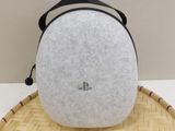 the back of a white and black bag sitting on top of a bamboo mat
