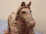 a wooden horse that is sitting on the ground