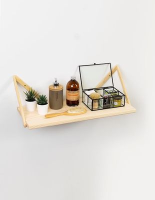 a wooden shelf with a mirror, a brush, and other items on it