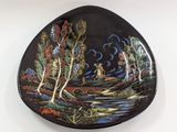 an image of a black plate with a painting of a river and trees