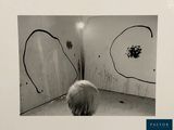black and white photograph of a child looking at a painting on a wall