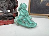 a statue of a man sitting on a rock next to a statue of a bird