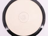 a close up of a white and black plate with a coin on it