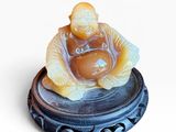 une petite figurine représentant un homme assis sur une assiette