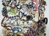 a close up of a pile of assorted jewelry on a white surface