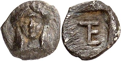 a silver coin with the letter t on it