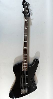 an electric bass guitar hanging on a wall with a white background